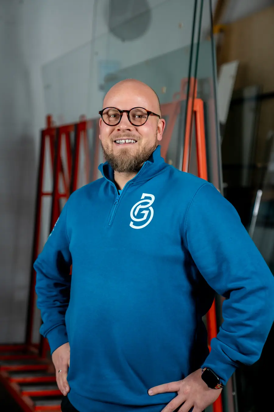 Dennis Bergmann, Inhaber von GlasPro Bergmann, vor Glasgestellen in der Halle